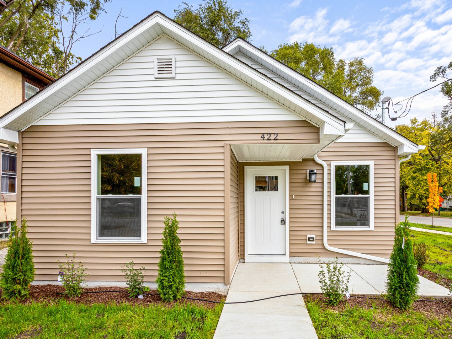 a view of a white house next to a yard