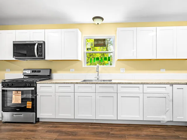 a kitchen with stainless steel appliances white cabinets and a sink