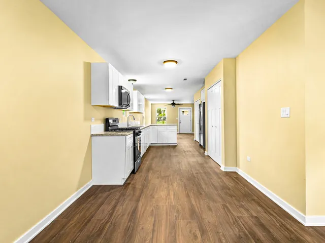 a view of a kitchen with kitchen island wooden floor center island and stainless steel appliances
