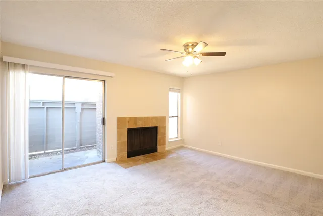 an empty room with windows and fireplace