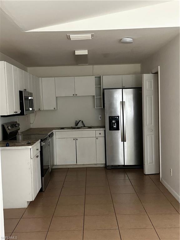 4746 15th Street Southwest Lehigh Acres, FL 33973 - Photo 3 of 4 a kitchen with stainless steel appliances granite countertop a refrigerator and a stove top oven
