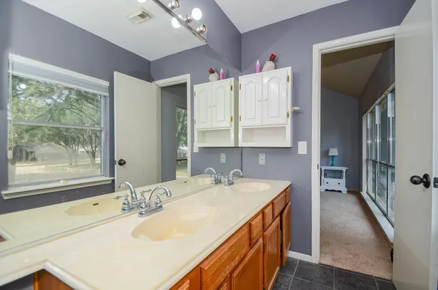 a bathroom with a granite countertop sink and a large mirror
