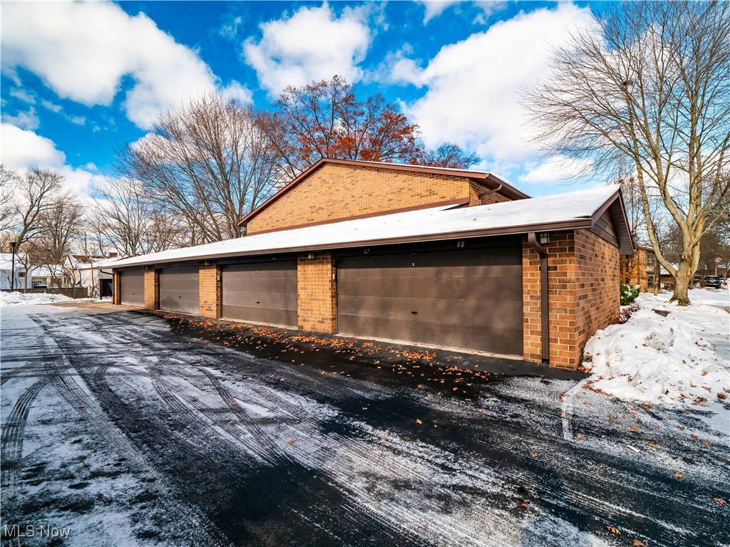 22968 Maple Ridge Road, Unit 103 North Olmsted, OH 44070 - Photo 16 of 25 Snow covered property featuring brick siding and an outdoor structure