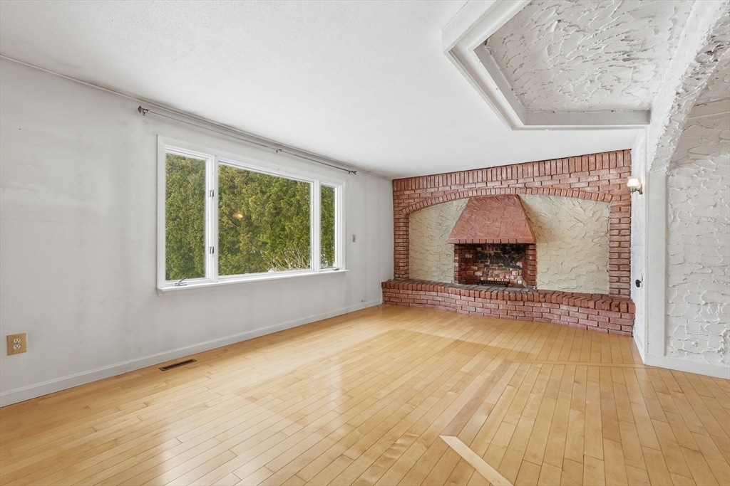 105 Pomeroy Lane Amherst, MA 01002 - Photo 11 of 40 an empty room with a fireplace and window