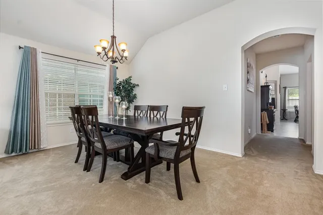 a view of a dining room with furniture and chandelier