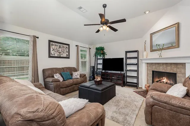 a living room with furniture a flat screen tv and a fireplace