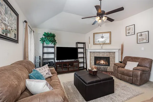 a living room with furniture a flat screen tv and a fireplace