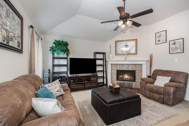 a living room with furniture a flat screen tv and a fireplace