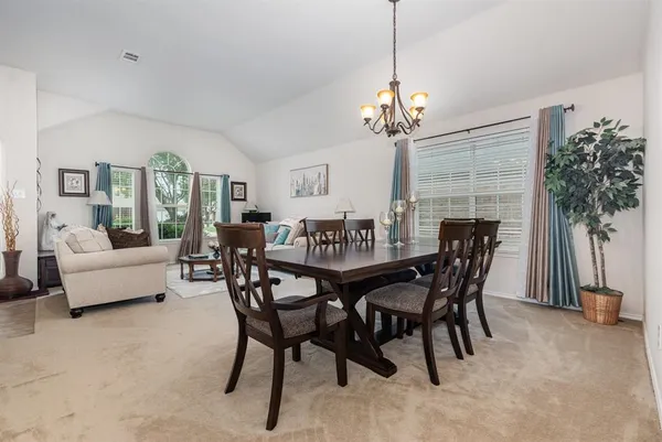 a view of a dining room with furniture and a chandelier