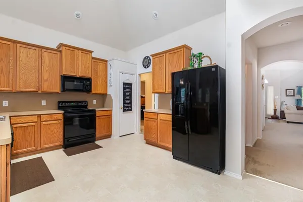 a kitchen with stainless steel appliances granite countertop a refrigerator and a stove top oven