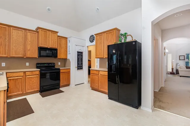 a kitchen with stainless steel appliances granite countertop a refrigerator and a stove top oven
