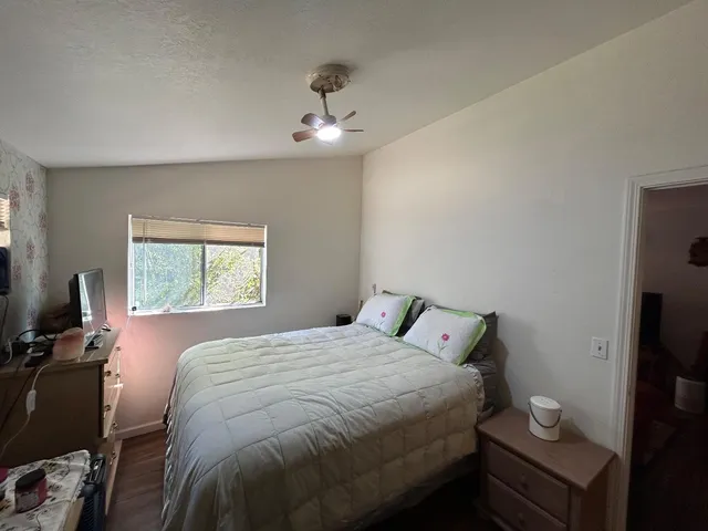 a bedroom with a bed and a flat tv screen on the dresser