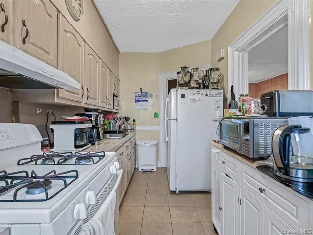 a kitchen with stainless steel appliances a refrigerator a sink a stove and wooden floors