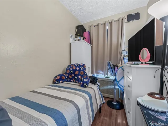 a bedroom with a bed and a painting on the wall