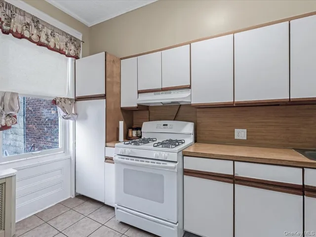 a kitchen with a stove sink and cabinets