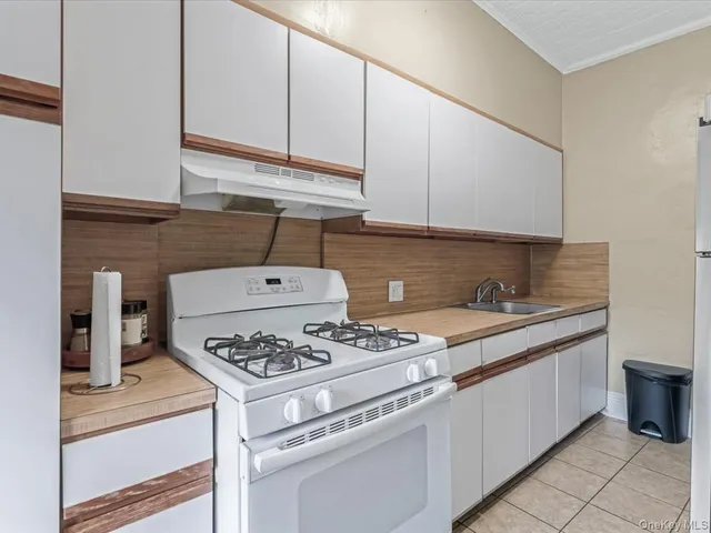 a white stove top oven sitting inside of a kitchen