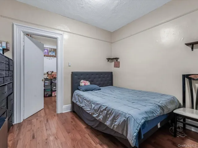 a bedroom with a bed and a wooden floor