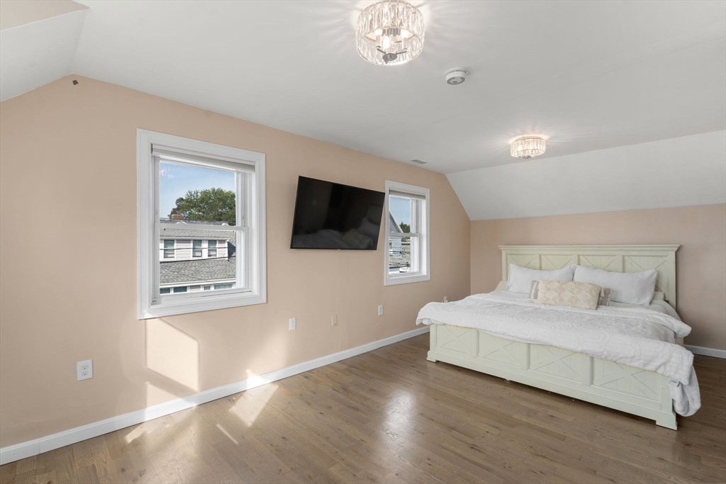 9 Marshall Street Winthrop, MA 02152 - Photo 12 of 34 a bedroom with a large bed a flat tv screen and a night stand