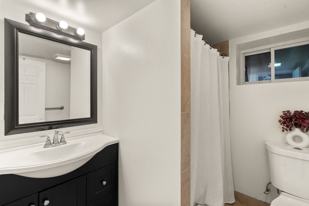 9 Marshall Street Winthrop, MA 02152 - Photo 21 of 34 a bathroom with a toilet a sink and mirror