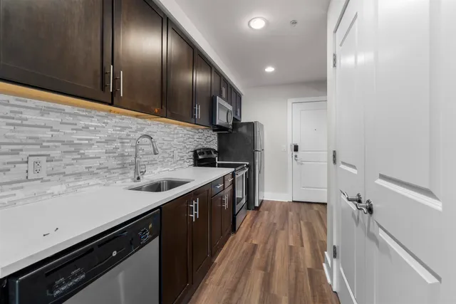 a kitchen with stainless steel appliances granite countertop a sink stove and cabinets