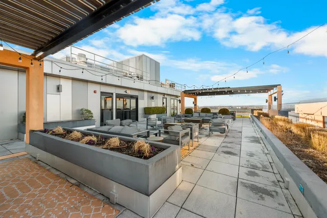 a view of a patio with lawn chairs fire pit and ocean view