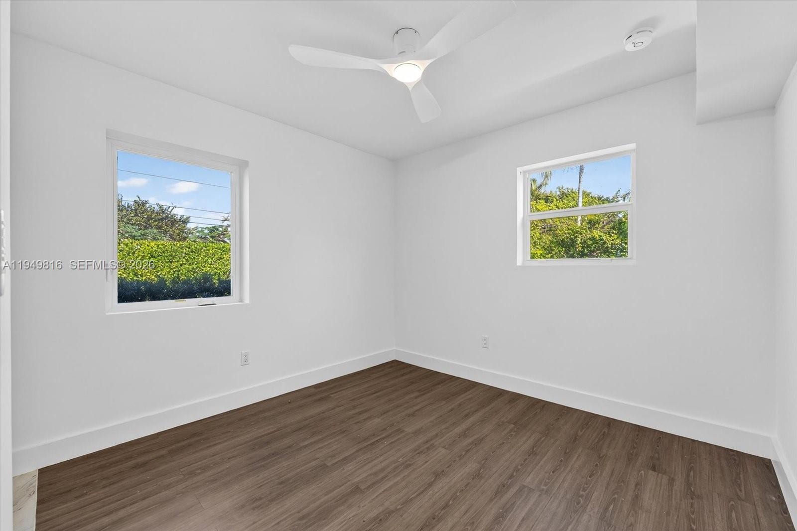 6735 Southwest 51st Street Miami, FL 33155 - Photo 12 of 34 an empty room with a window and wooden floor