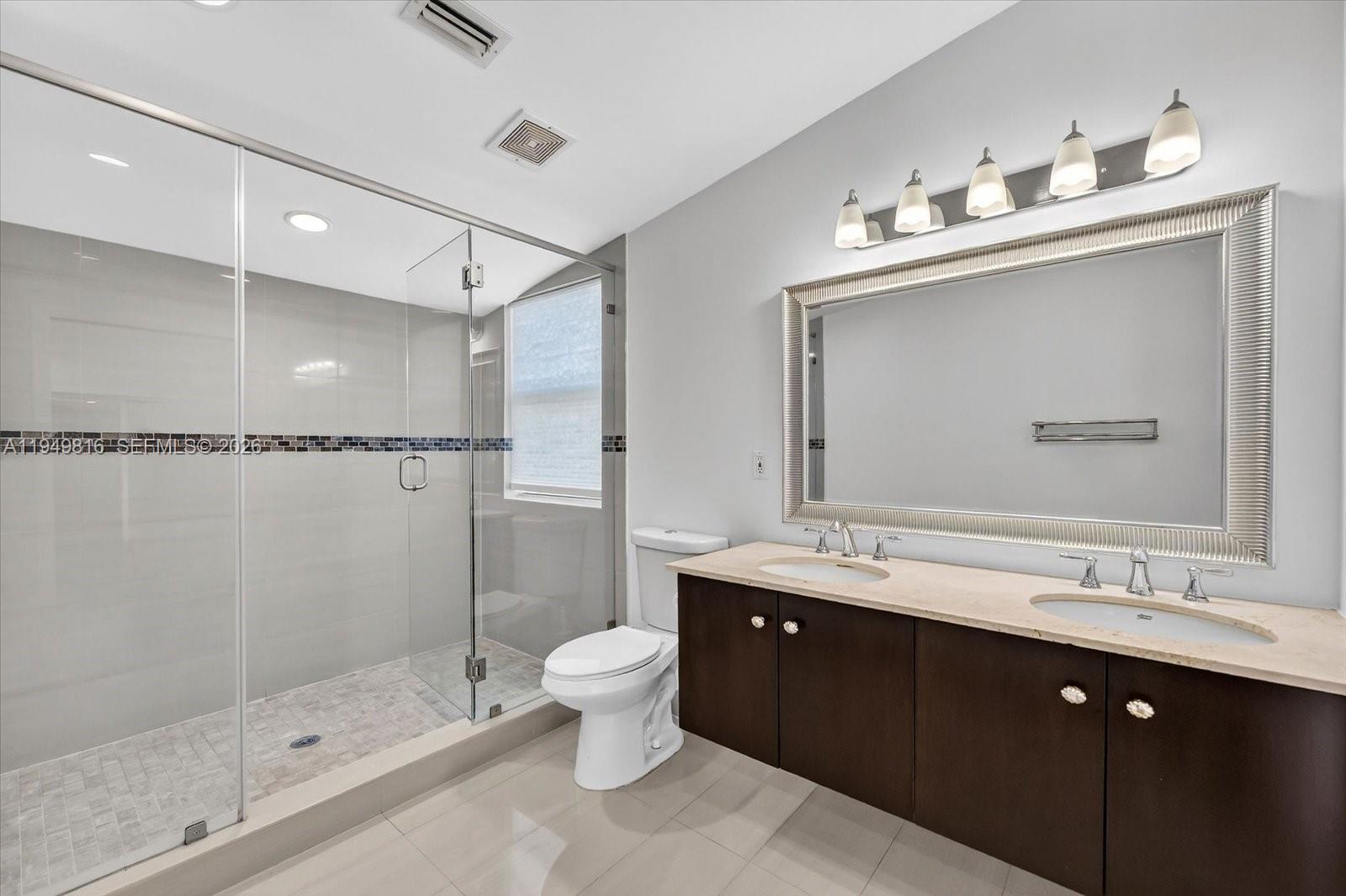 6735 Southwest 51st Street Miami, FL 33155 - Photo 18 of 34 a bathroom with a double vanity sink mirror and shower