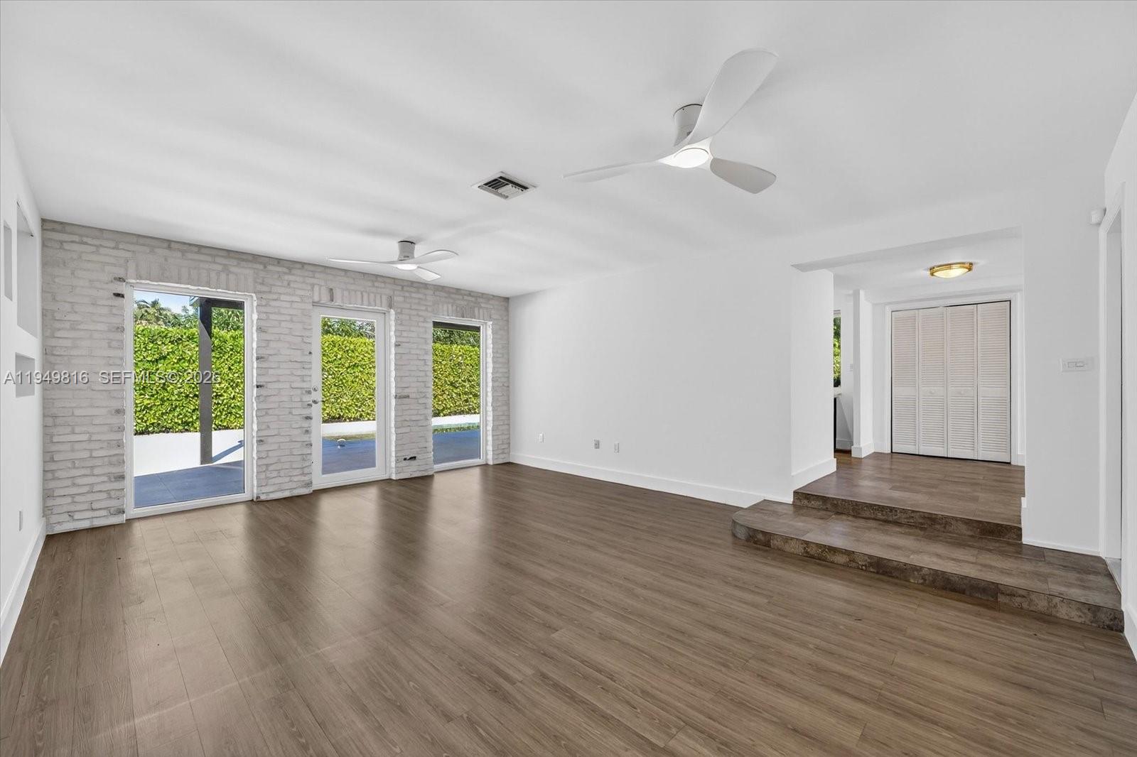 6735 Southwest 51st Street Miami, FL 33155 - Photo 4 of 34 a view of an empty room with wooden floor and a window