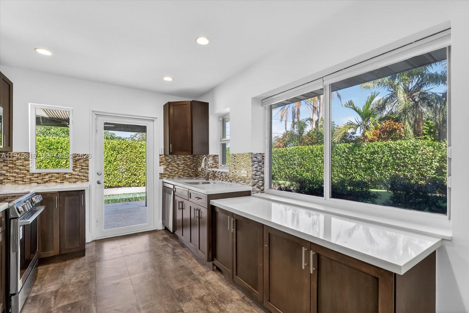6735 Southwest 51st Street Miami, FL 33155 - Photo 9 of 34 a kitchen with a stove a sink and a refrigerator