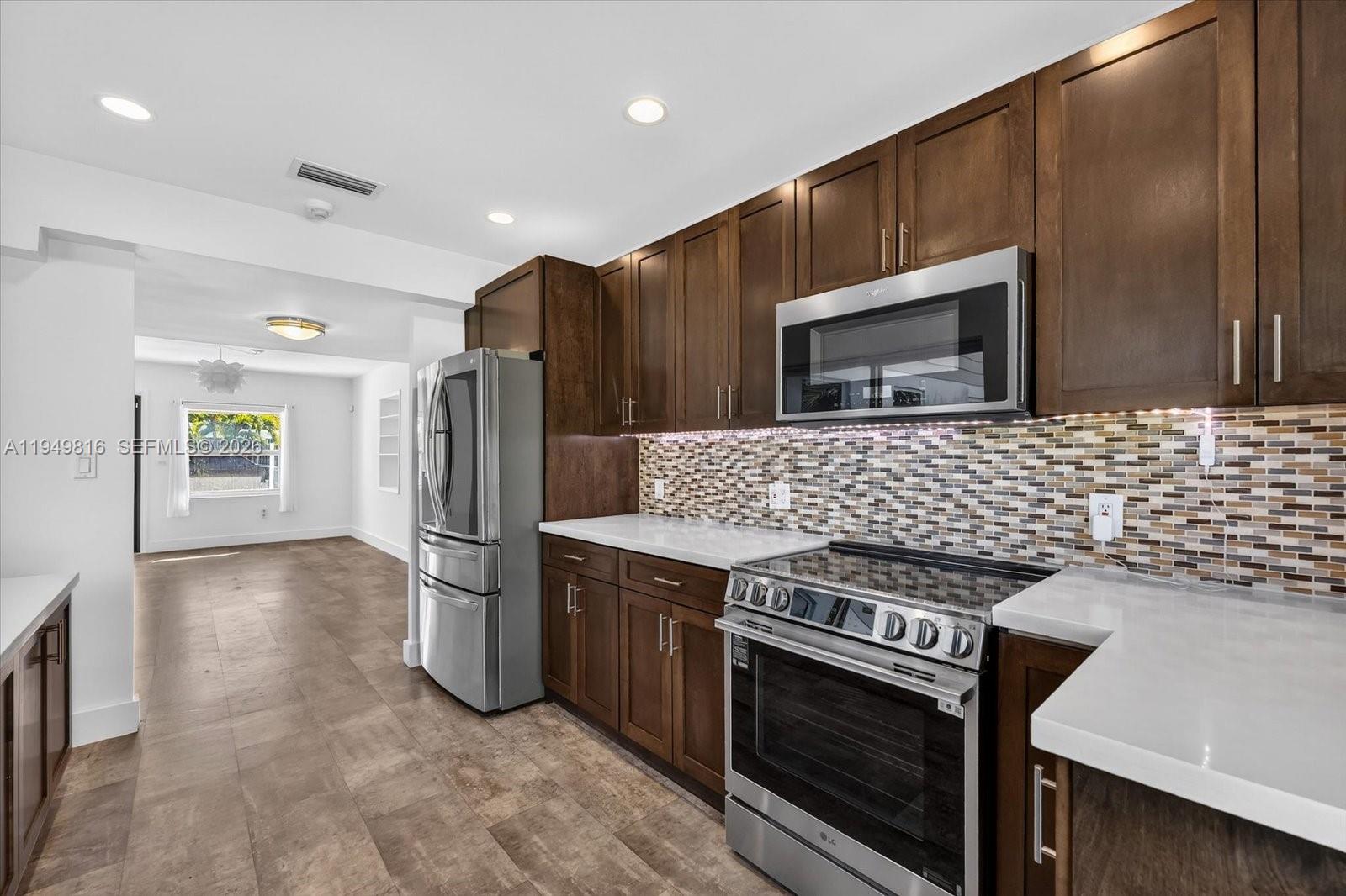 6735 Southwest 51st Street Miami, FL 33155 - Photo 10 of 34 a kitchen with stainless steel appliances a stove a microwave and a refrigerator
