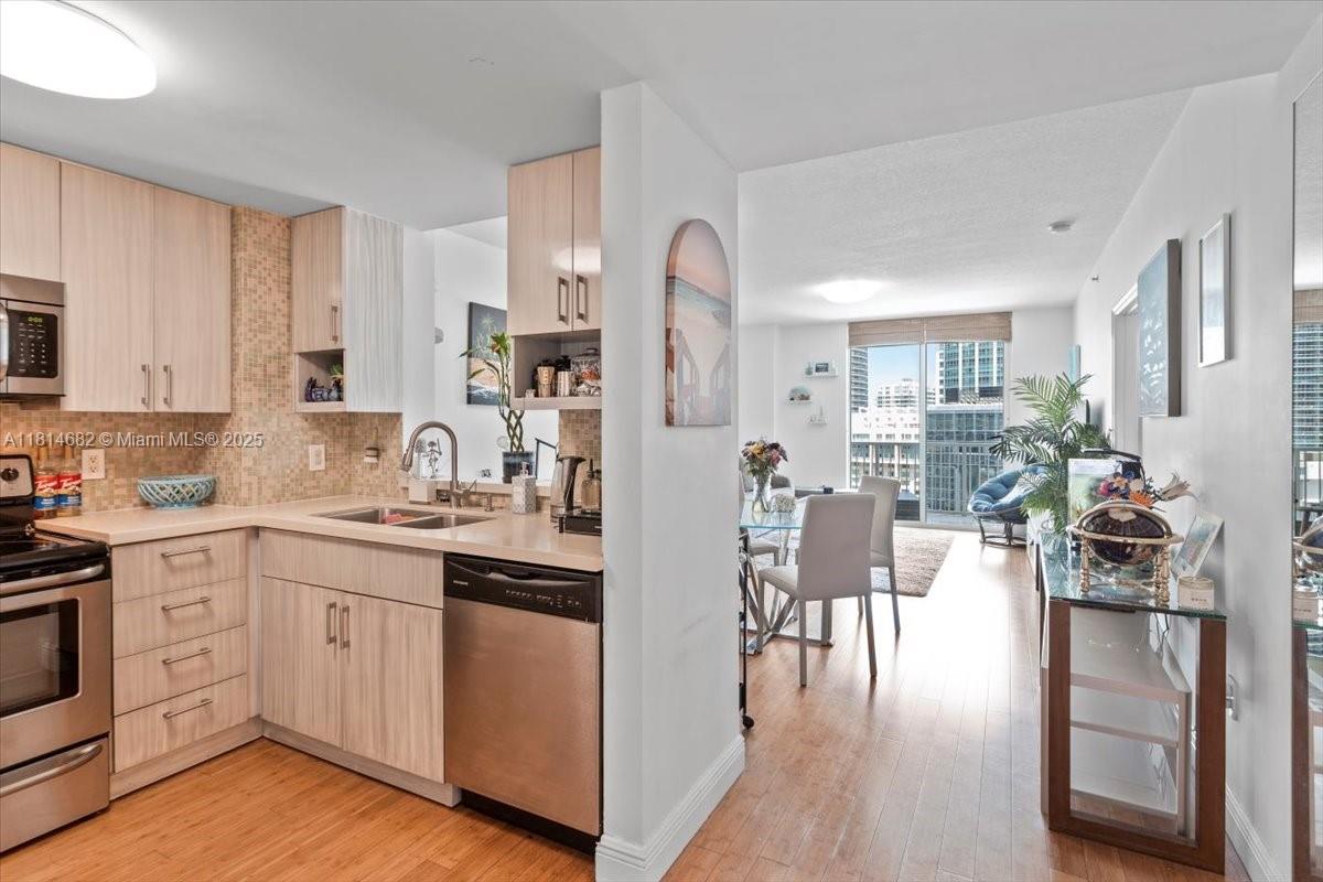 1250 South Miami Avenue, Unit 2208 Miami, FL 33130 - Photo 4 of 28 a kitchen with white cabinets and stainless steel appliances