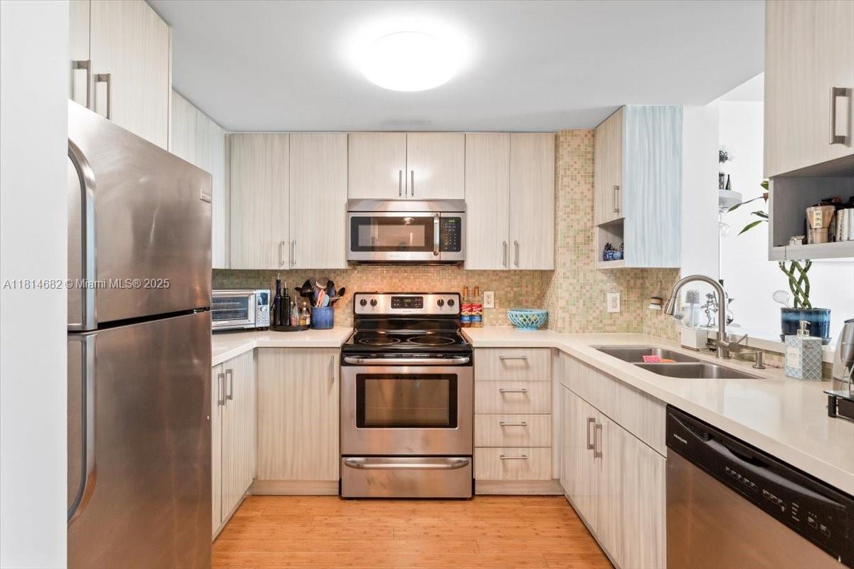 1250 South Miami Avenue, Unit 2208 Miami, FL 33130 - Photo 6 of 28 a kitchen with white cabinets and stainless steel appliances