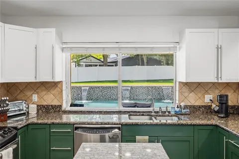 a kitchen with stainless steel appliances granite countertop a sink a stove and a microwave