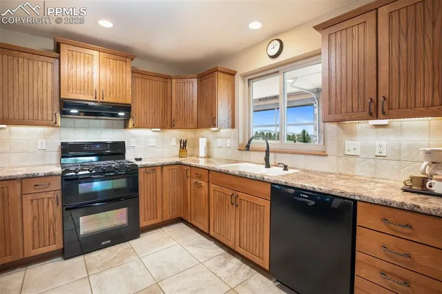 a kitchen with granite countertop a sink stainless steel appliances and cabinets