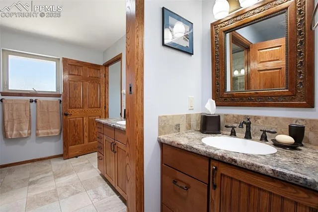 a bathroom with a granite countertop sink and a mirror