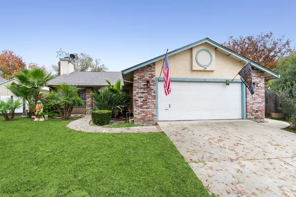 a view of a house with a yard and potted plants