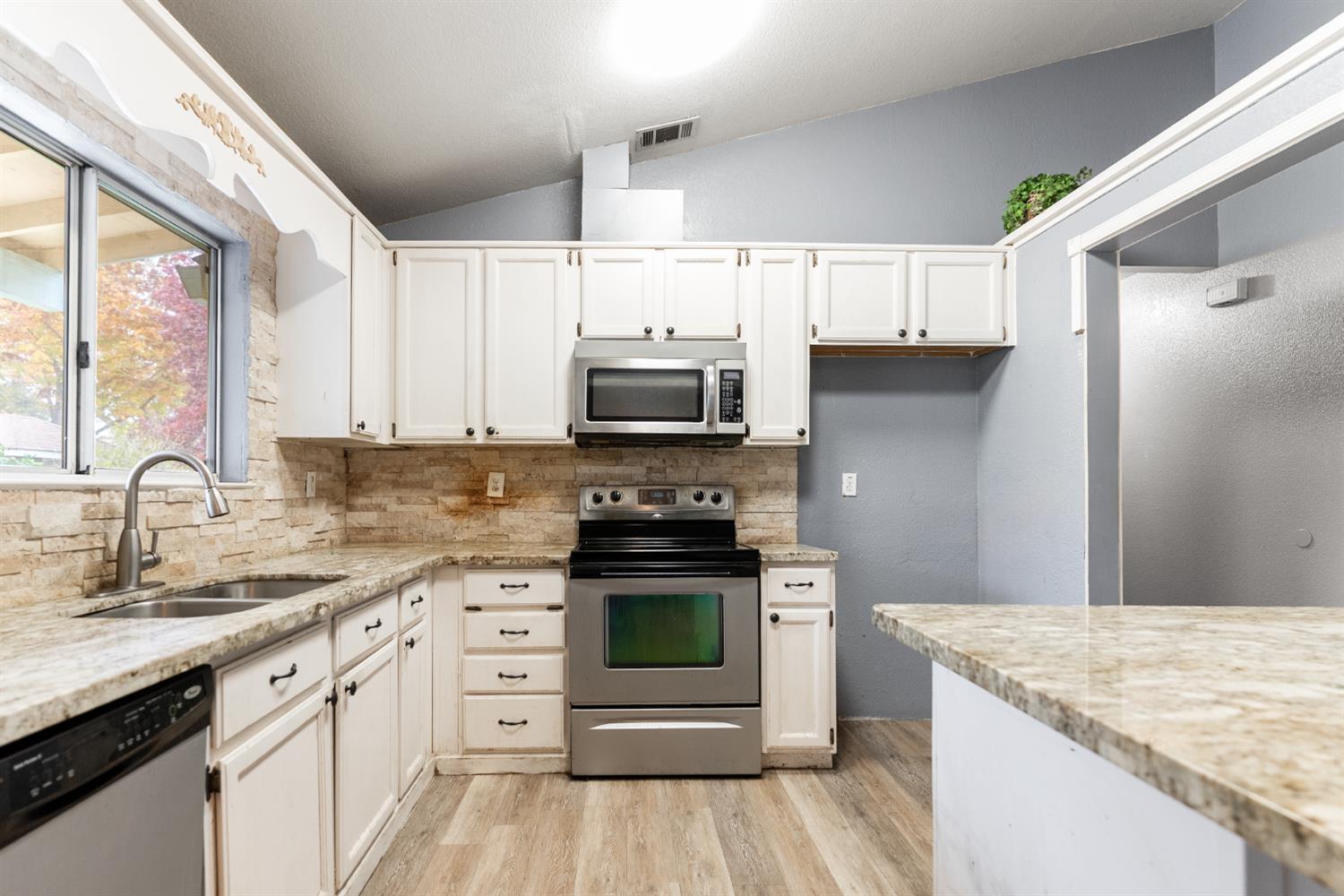 600 Sears Drive Patterson, CA 95363 - Photo 11 of 44 a kitchen with a stove a sink and a microwave