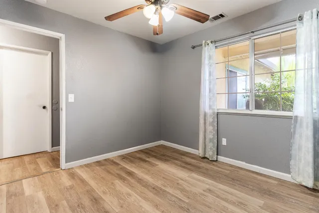 an empty room with a window and wooden floor