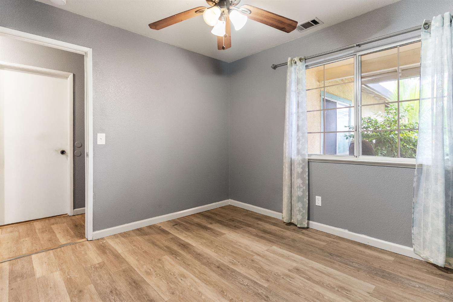 600 Sears Drive Patterson, CA 95363 - Photo 23 of 44 an empty room with a window and wooden floor