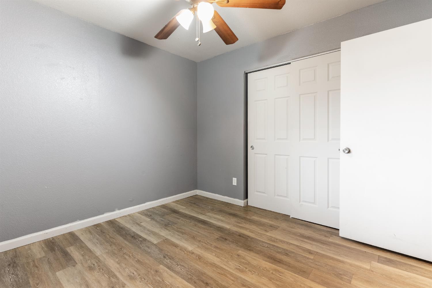 600 Sears Drive Patterson, CA 95363 - Photo 25 of 44 an empty room with a ceiling fan and wooden floor