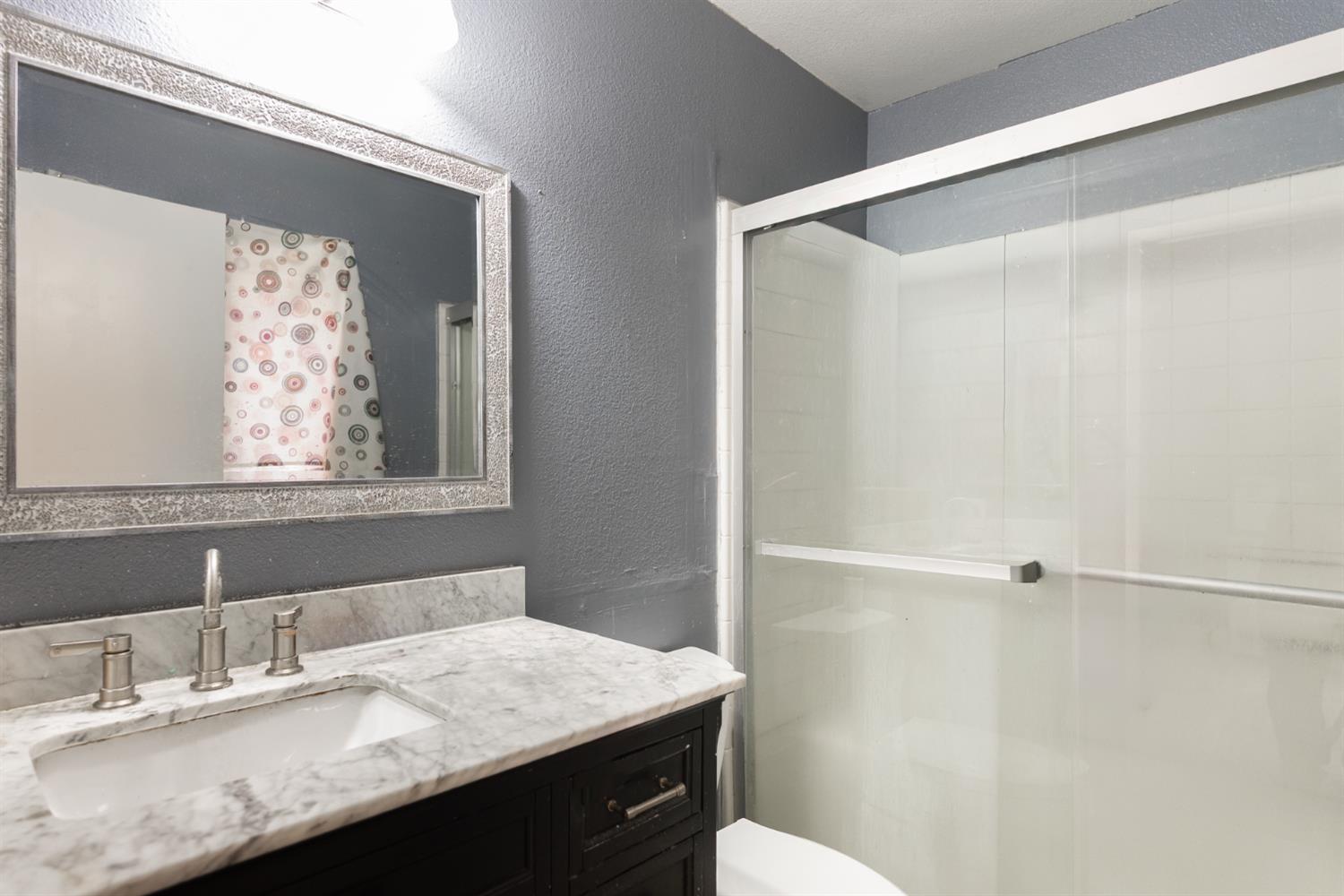 600 Sears Drive Patterson, CA 95363 - Photo 34 of 44 a bathroom with a granite countertop sink mirror vanity and toilet