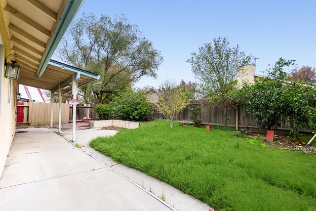 a view of a backyard with table and chairs and a fire pit