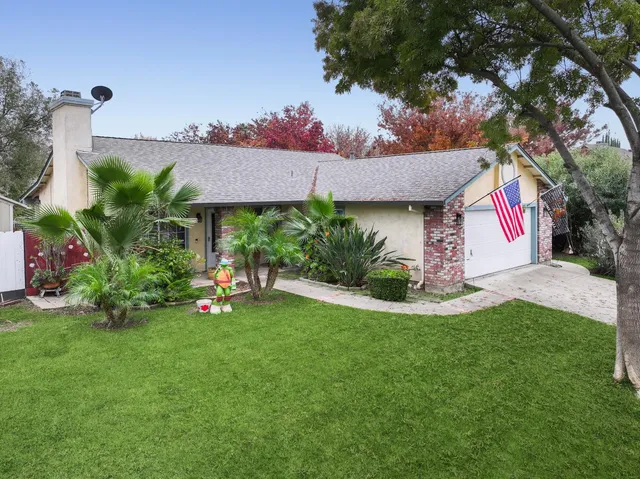 a view of a house with a backyard and a tree
