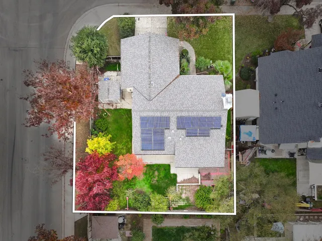 an aerial view of a house with a yard and a large pool