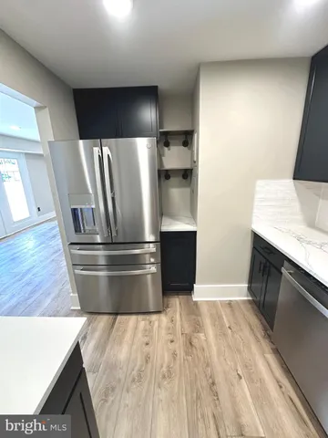 a view of kitchen with a sink wooden cabinet and a refrigerator