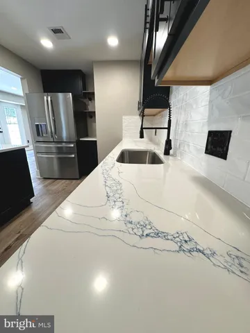 a large white kitchen with a sink and stainless steel appliances