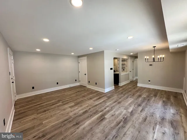 a view of a big room with wooden floor and windows