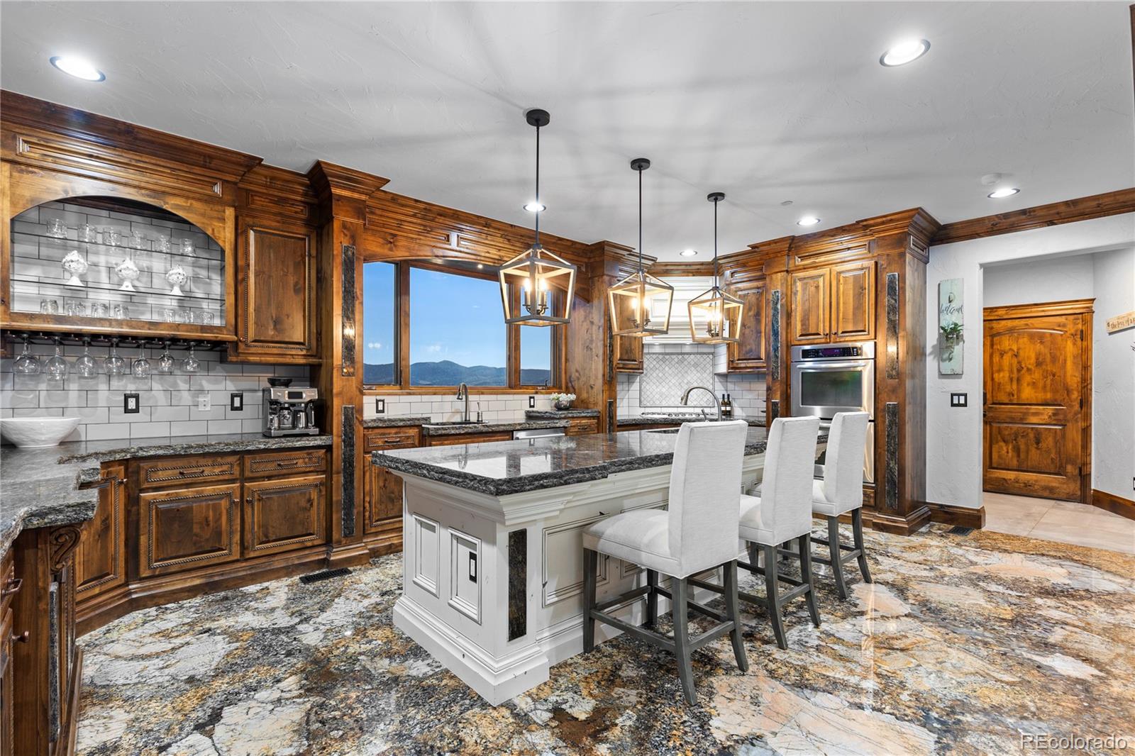 100 Halter Way Evergreen, CO 80439 - Photo 12 of 40 a kitchen with granite countertop a stove a sink a dining table and chairs