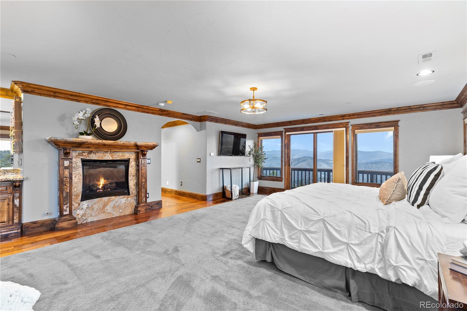 100 Halter Way Evergreen, CO 80439 - Photo 20 of 40 a bedroom with a bed and a fireplace