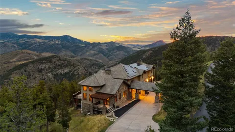 a view of a big house with table and chairs